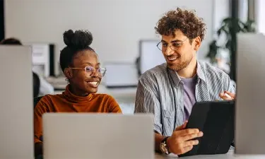 IT students working together in a computer lab, showcasing teamwork and hands-on learning in the Information Technology program.